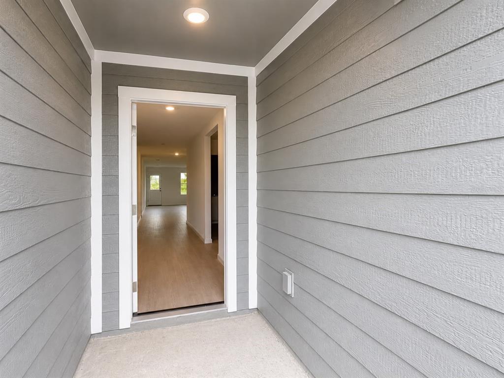 A view from a covered porch looking through an open doorway into a home interior — 431 ARTEMIS STREET, LAKE WALES, FL