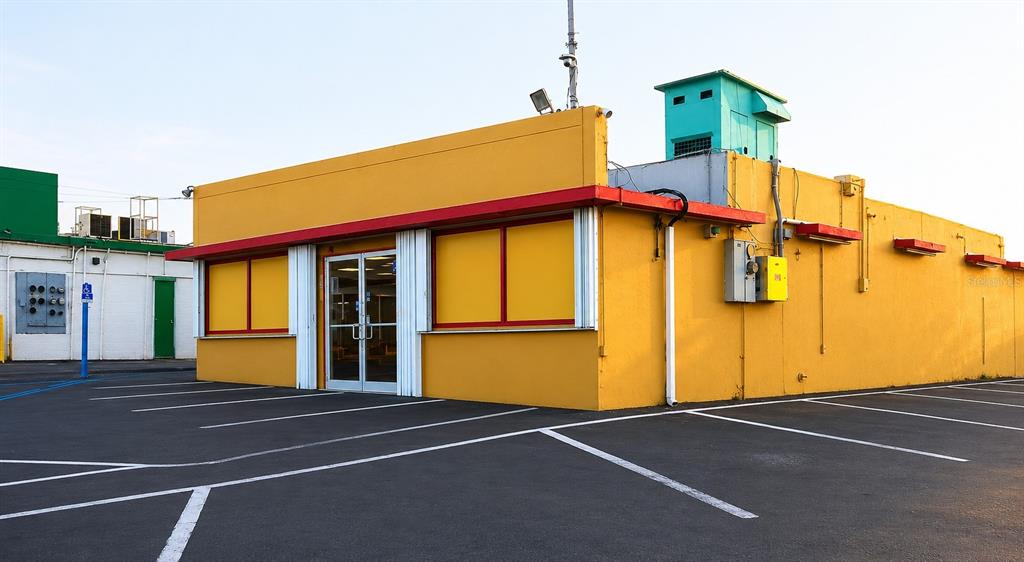 A yellow commercial building with a flat roof and a parking lot in the foreground — PR-167 KM 16.1 BUENA VISTA WARD - FALCON SECTOR, BAYAMON, PR