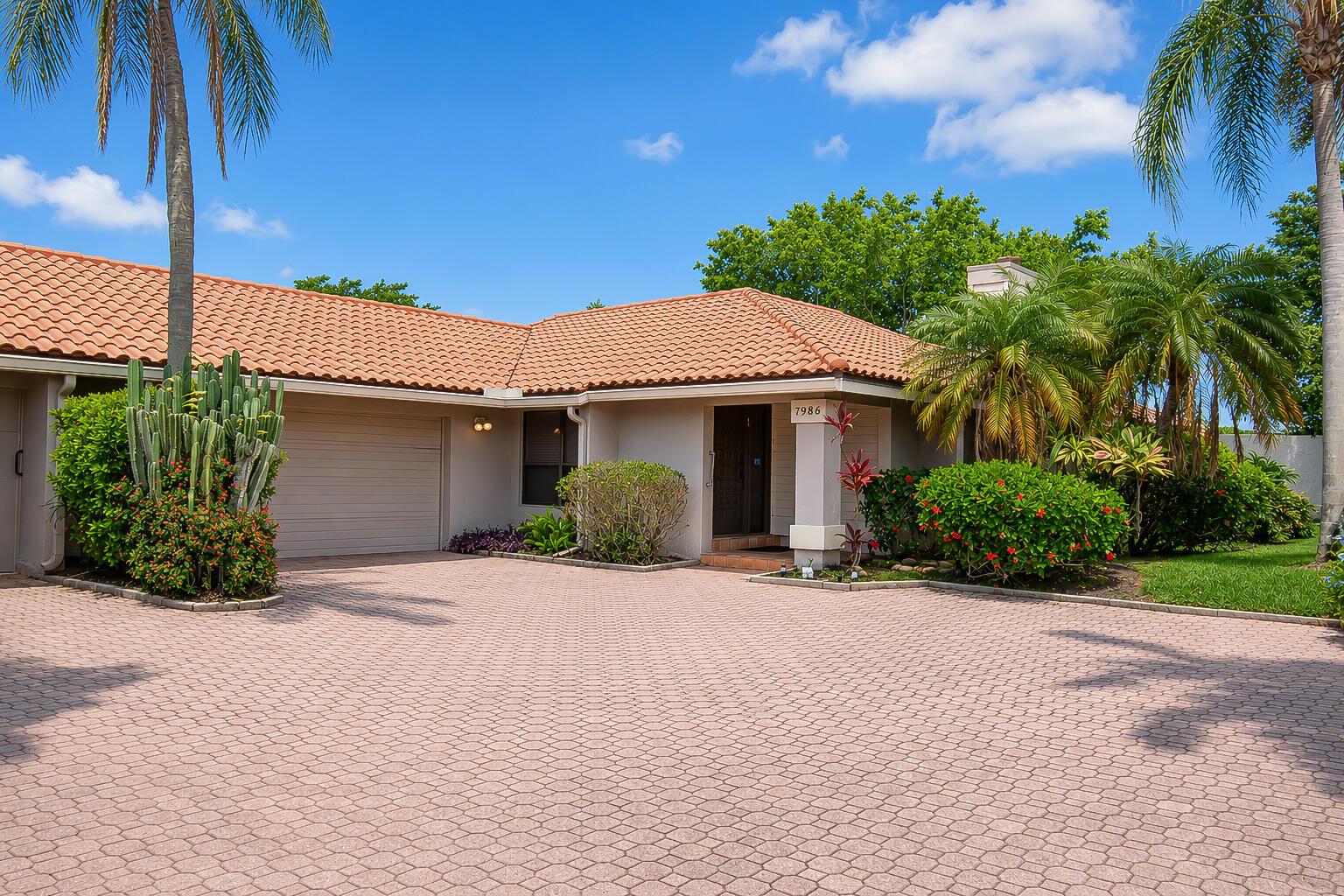 A single-story house with a tiled roof, a paved driveway, and lush landscaping — 7986 Palacio Del Mar Drive, Boca Raton FL 33433, BOCA RATON, FL