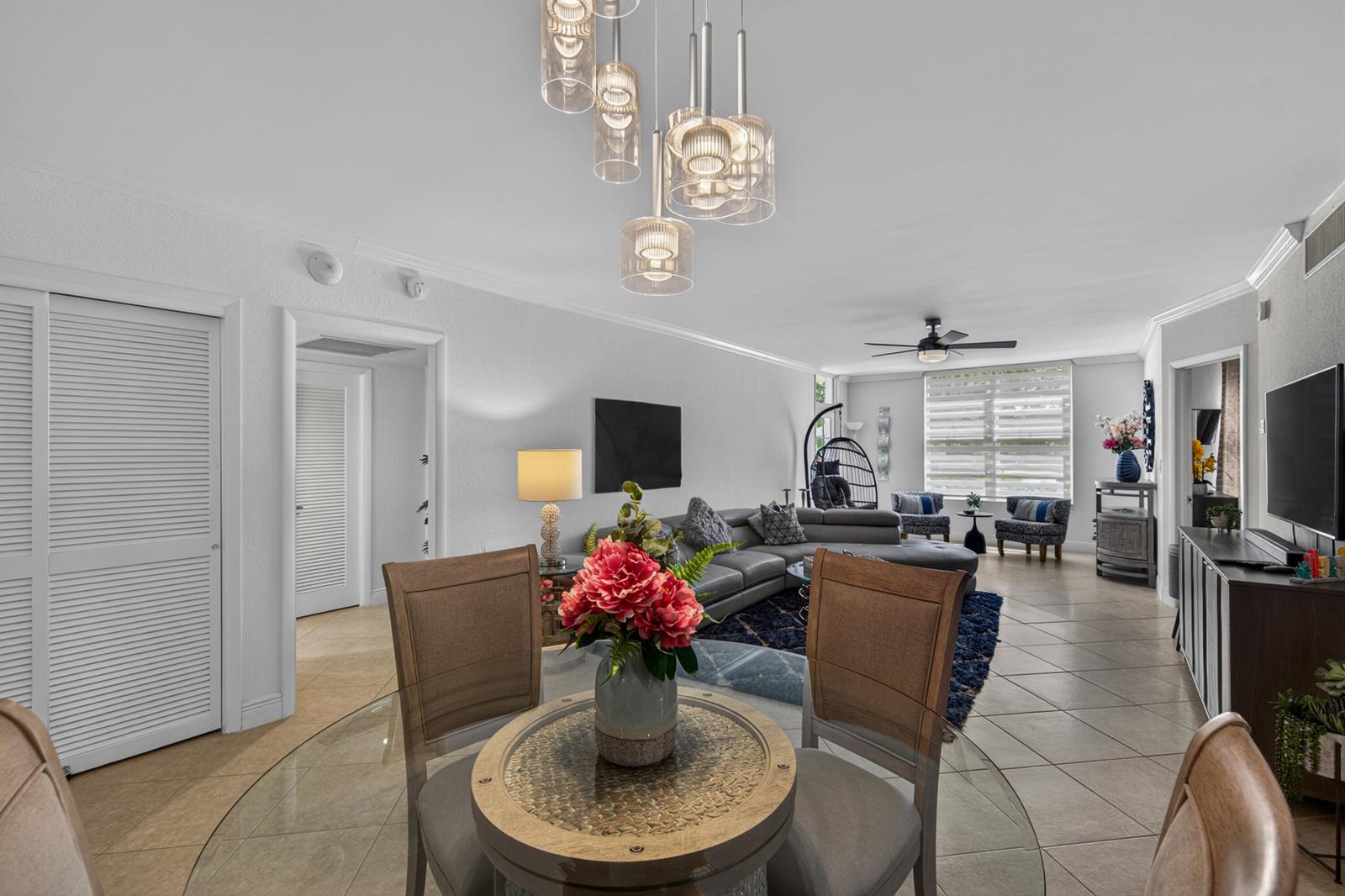 A dining area with a glass table overlooks an open-concept living room with tile flooring — 2851 S Ocean Boulevard # 1n, Boca Raton FL 33432, BOCA RATON, FL