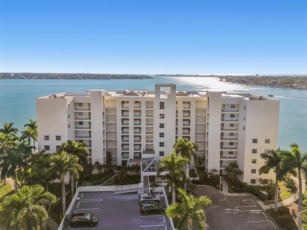 An aerial view of a multi-story white apartment building situated along a waterfront — 6105 BAHIA DEL MAR CIRCLE UNIT 686, ST PETERSBURG, FL