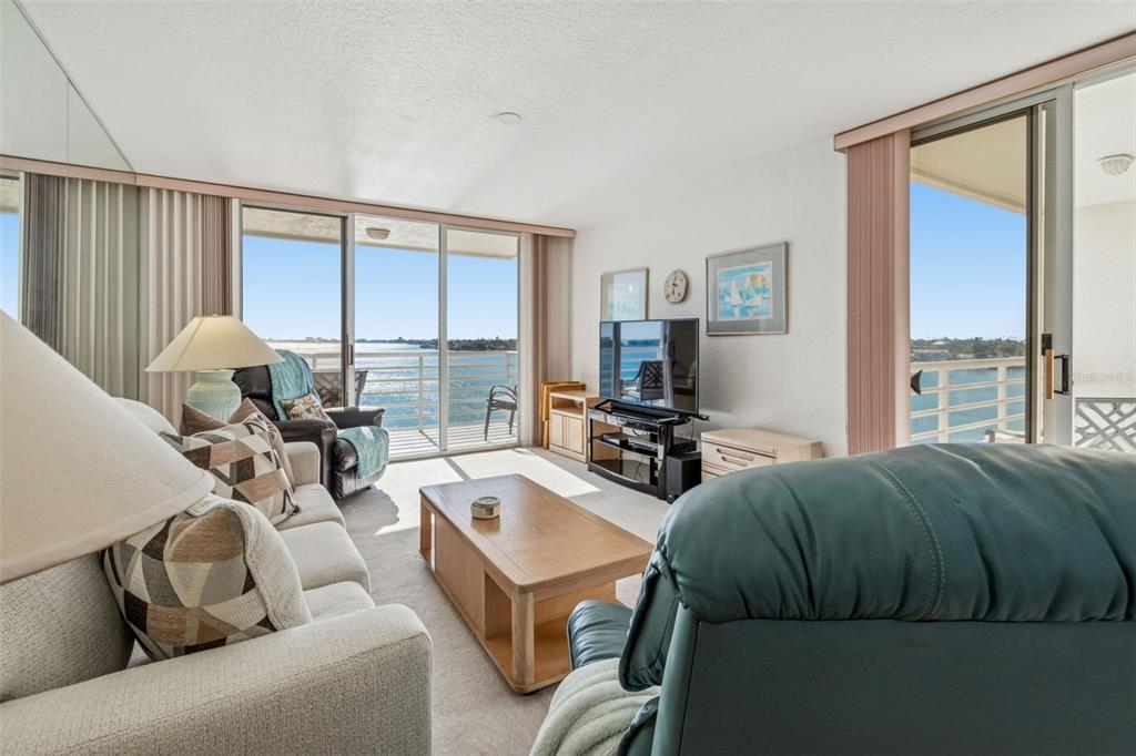 A living room features a sofa, a recliner, a coffee table, and sliding glass balcony doors — 6105 BAHIA DEL MAR CIRCLE UNIT 686, ST PETERSBURG, FL
