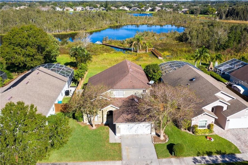 An aerial view shows a suburban house with a garage, driveway, and a backyard lake — 3701 SEMINOLE DRIVE, ORLANDO, FL