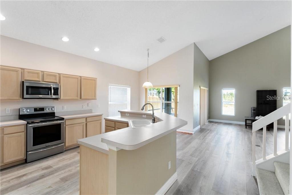 A kitchen with light wood cabinets, stainless steel appliances, and a peninsula island — 3701 SEMINOLE DRIVE, ORLANDO, FL