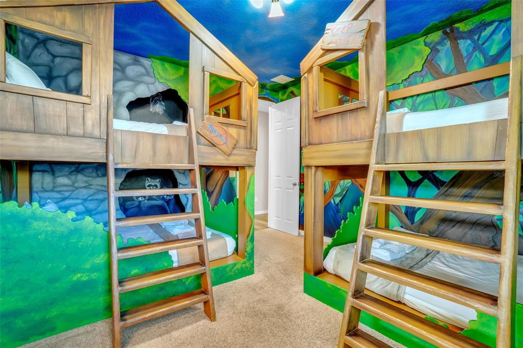 A game room features a ping pong table, two wall-mounted televisions, and an arcade game — 9014 SUNSHINE RIDGE LOOP, KISSIMMEE, FL