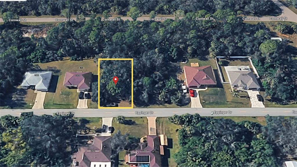 An aerial view shows a vacant, tree-covered residential lot situated between two houses on a street — 1367 EPPINGER DRIVE, PORT CHARLOTTE, FL