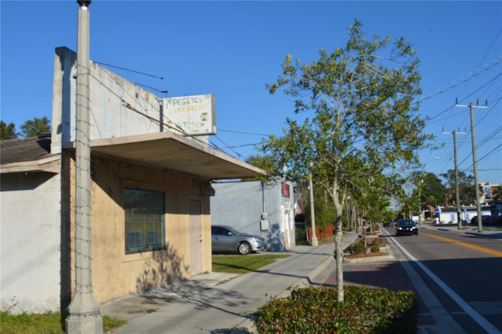 A street-level view of a tan commercial building with a small sign and sidewalk — 1006 S HISTORIC GOLDSBORO, SANFORD, FL