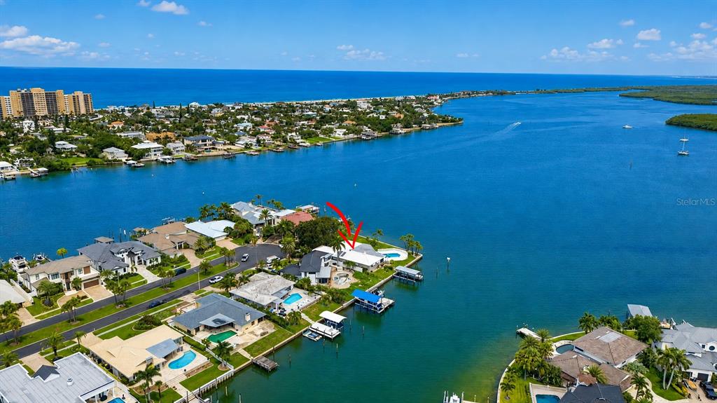 An aerial view shows a waterfront house with a pool and boat dock — 891 ISLAND WAY, CLEARWATER BEACH, FL