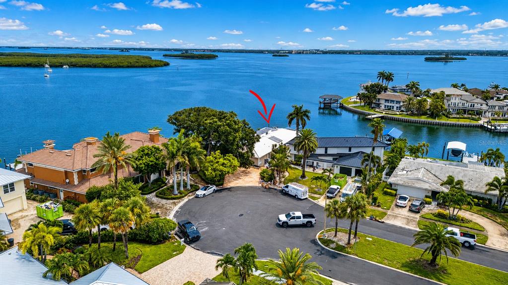 An aerial view shows waterfront homes with palm trees and a cul-de-sac street — 891 ISLAND WAY, CLEARWATER BEACH, FL