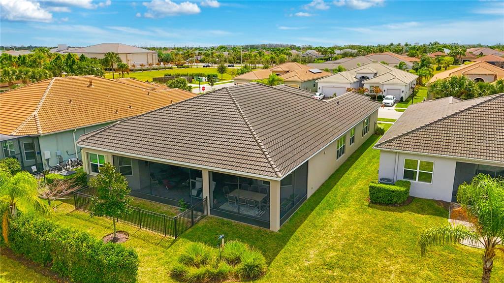 An aerial view shows the back of a house with a screened-in patio and yard — 4924 PAMPLONA COURT, WIMAUMA, FL