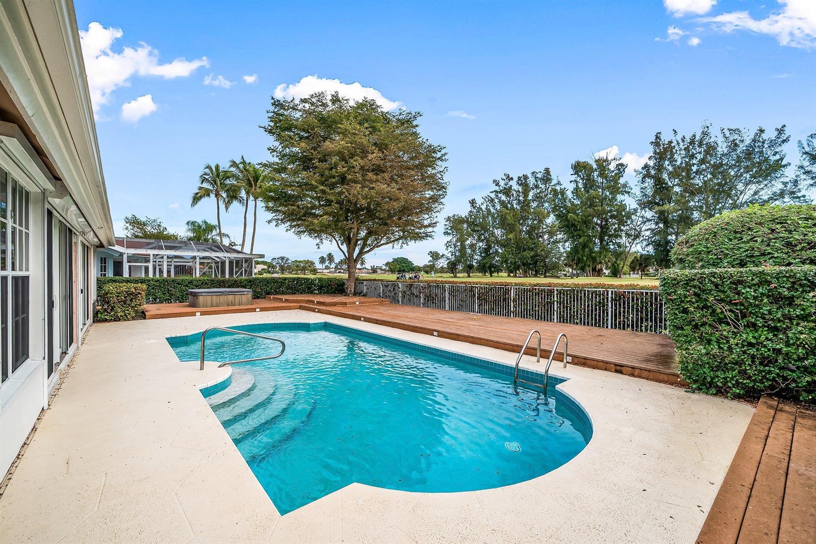A backyard features a swimming pool, a wooden deck, a hot tub, and golf course views — 230 Eagleton Estate Boulevard, Palm Beach Gardens FL 33418, PALM BEACH GARDENS, FL