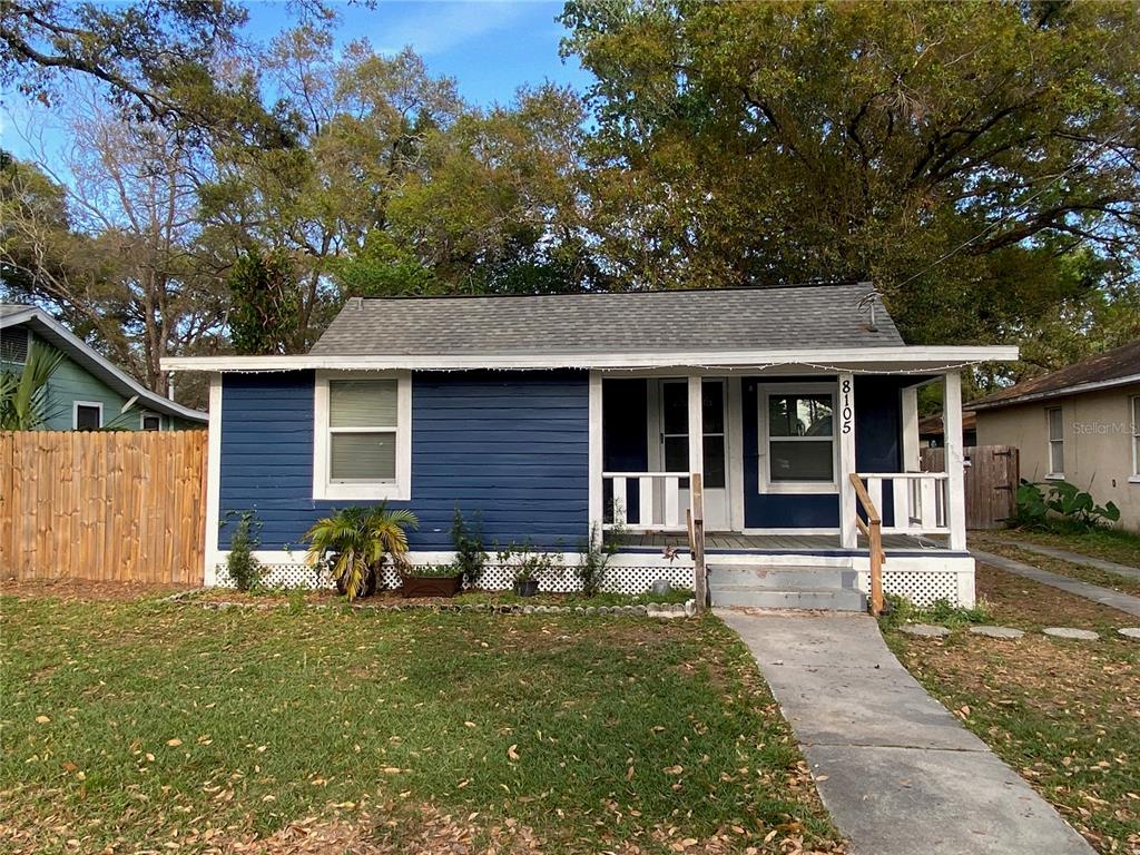 A blue, single-story house with a front porch and a concrete walkway — 8105 N 12TH STREET, TAMPA, FL