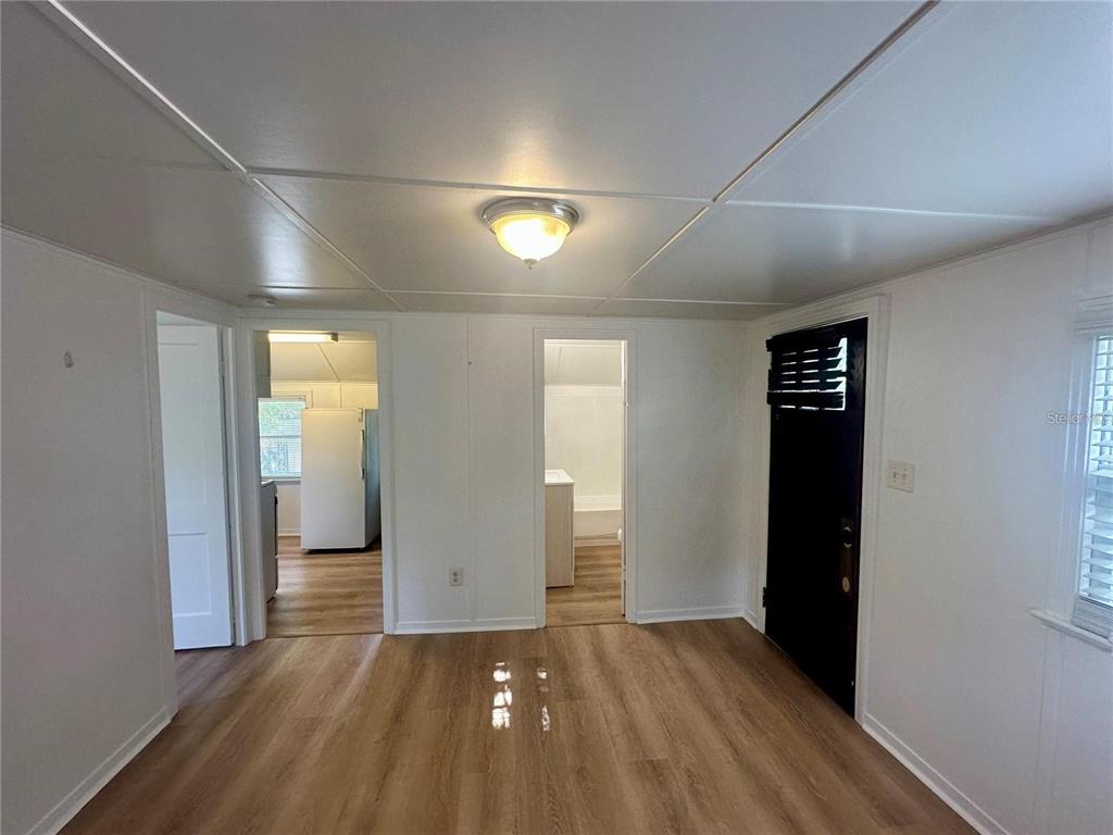 A room with light wood-look flooring, white walls, a ceiling light, and two doorways — 15 1/2 4TH STREET N, LAKE WALES, FL