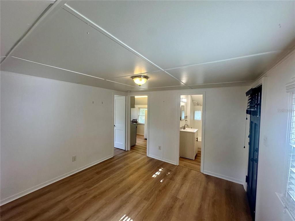 A room with wood-look flooring, white walls, a ceiling light, and two doorways — 15 1/2 4TH STREET N, LAKE WALES, FL