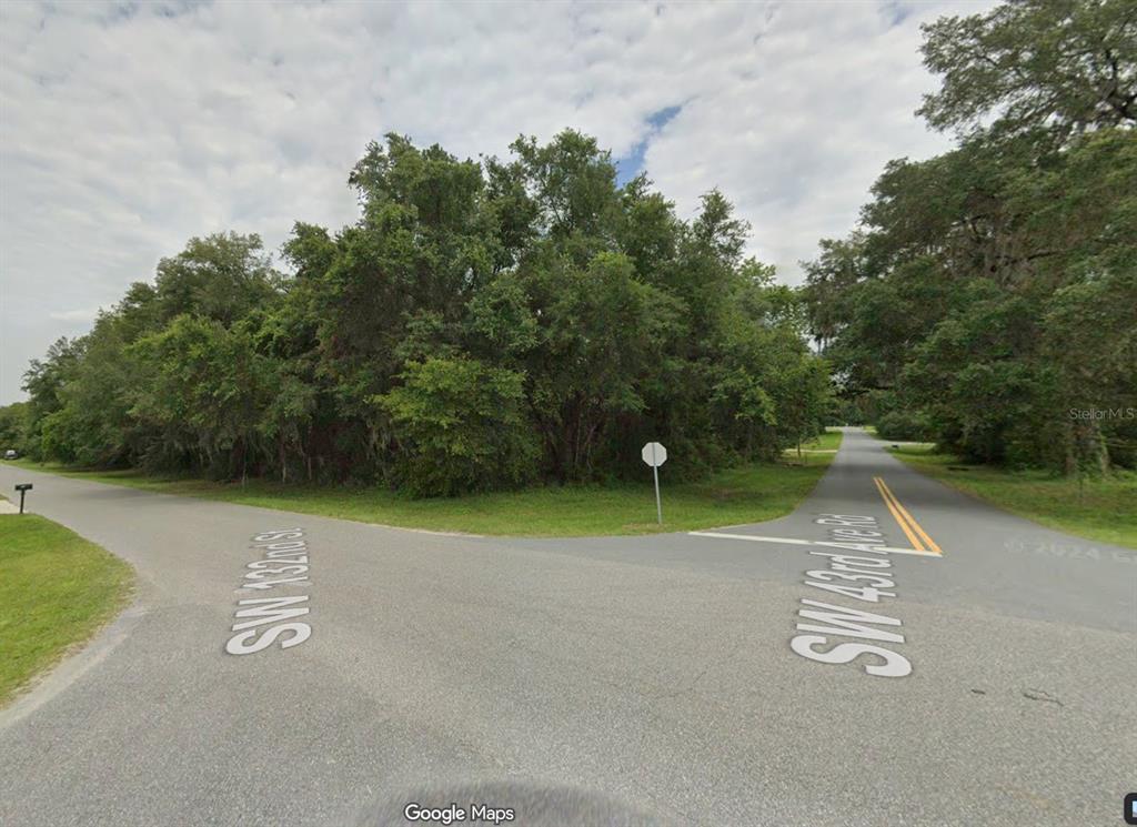 A street intersection with a stop sign and dense trees in the background — LOT 20 SW 132ND STREET, OCALA, FL