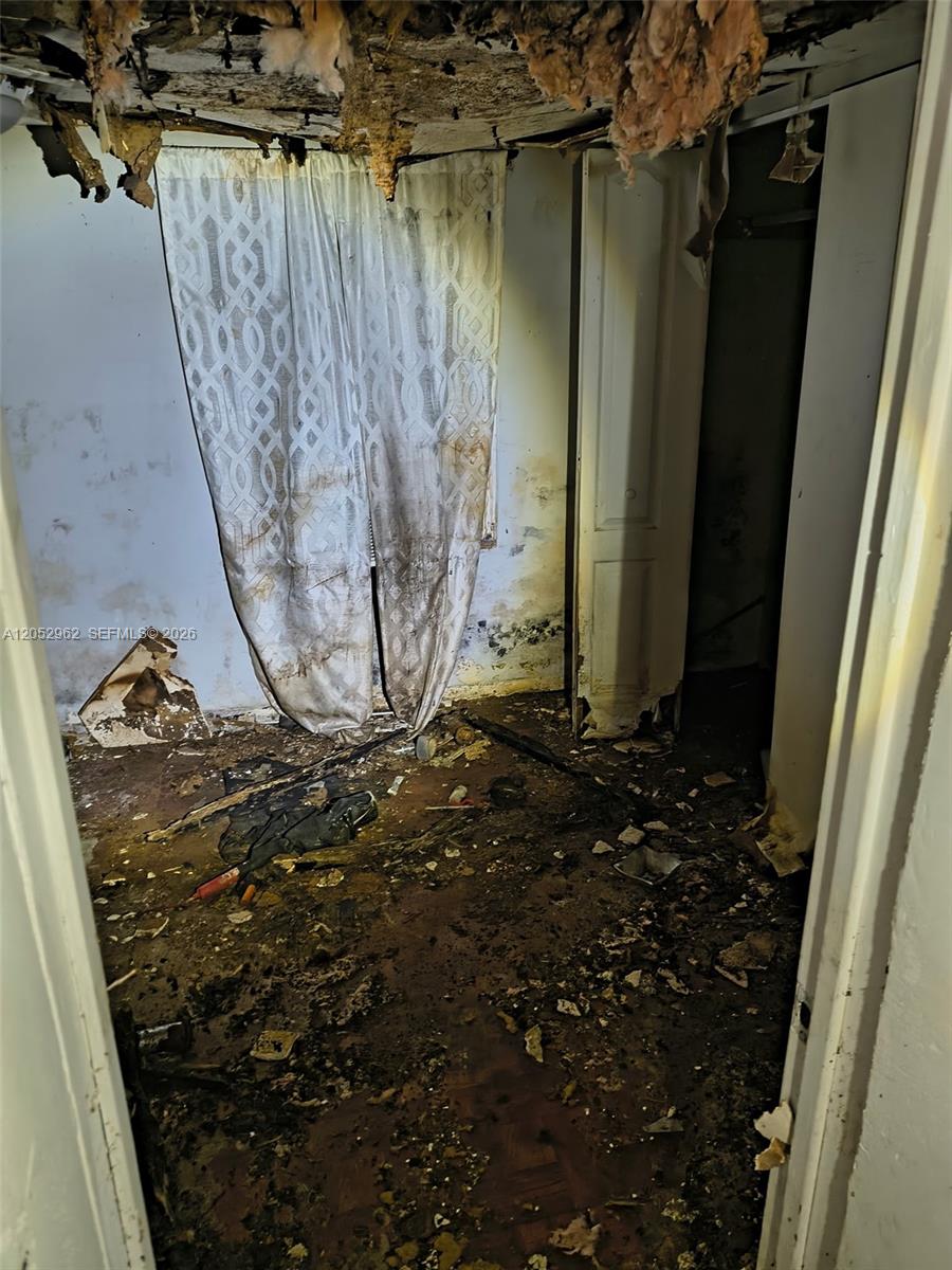 A dilapidated room features a collapsed ceiling, water-damaged walls, and debris covering the floor — 214 N 61st Ter, Hollywood FL 33024, HOLLYWOOD, FL