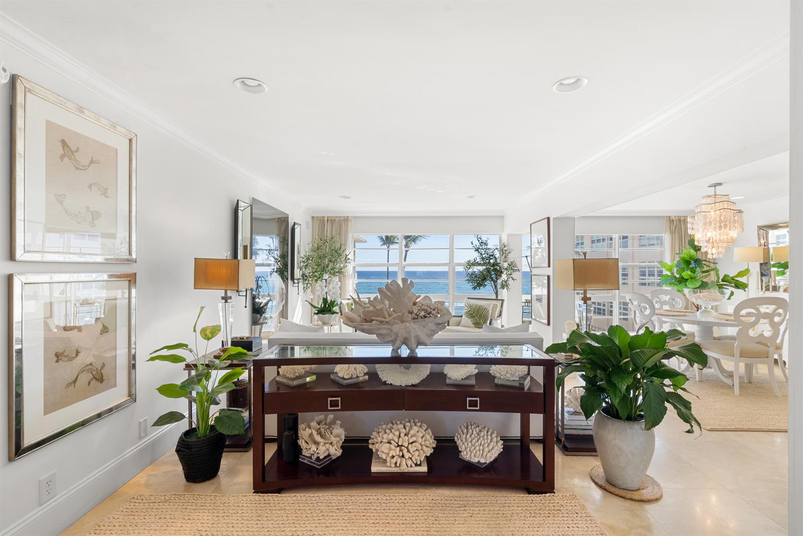 A bright living room features a console table with coral decor, plants, and ocean views — 3851 N Ocean Boulevard # 308, Gulf Stream FL 33483, GULF STREAM, FL