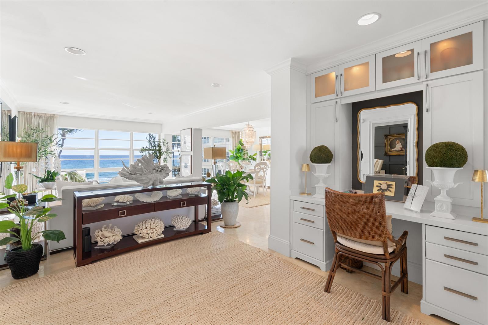A bright living area features a built-in desk, coastal decor, and a view of the ocean — 3851 N Ocean Boulevard # 308, Gulf Stream FL 33483, GULF STREAM, FL