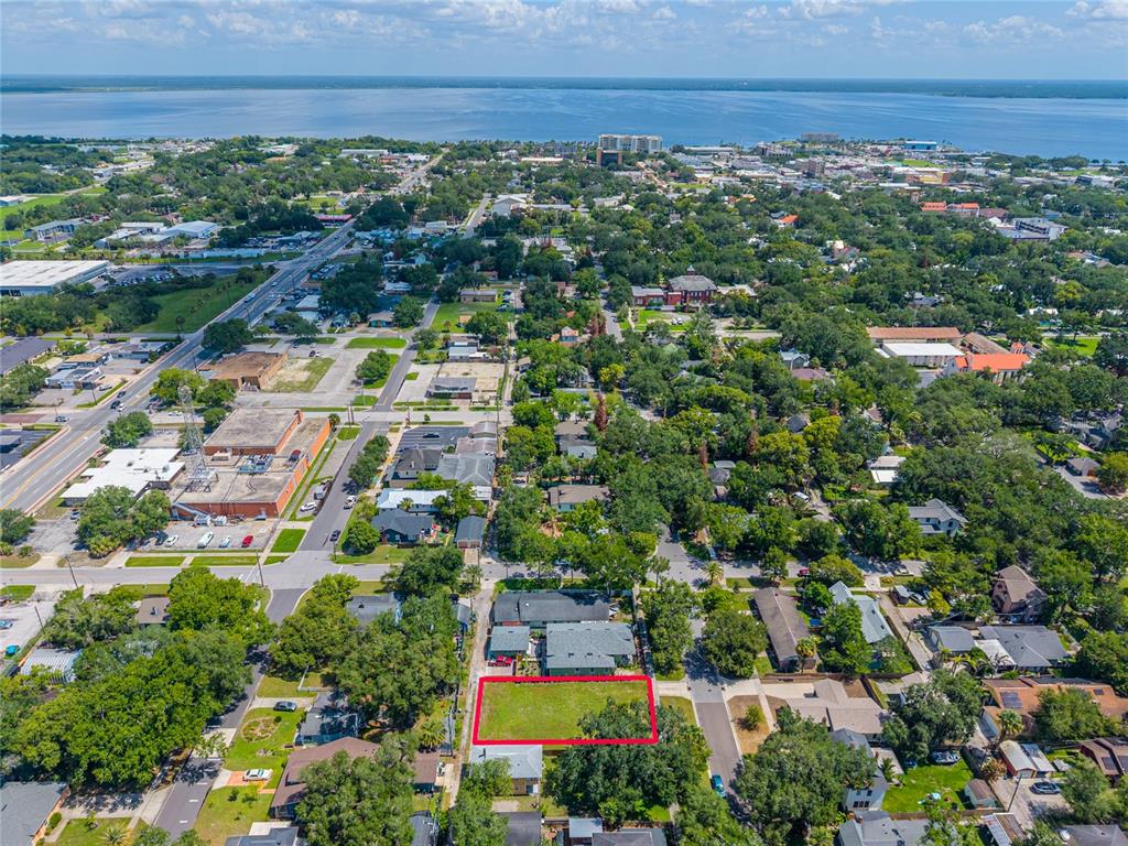 An aerial view shows a rectangular vacant lot outlined in red within a residential neighborhood — 1010 ELM AVENUE, SANFORD, FL
