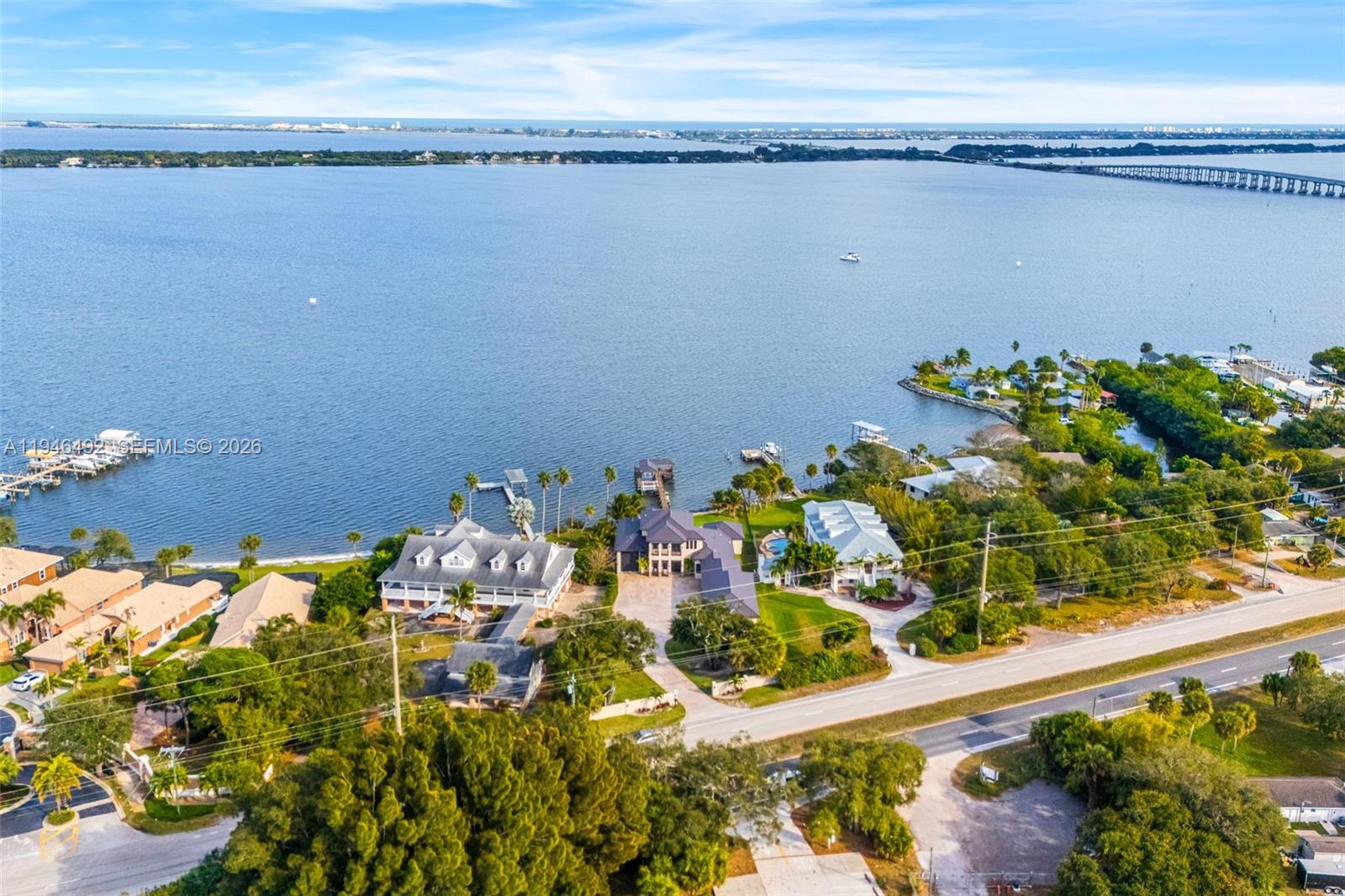 An aerial view shows waterfront homes with private docks along a large bay — 6275 N Highway 1, Melbourne FL 32940, MELBOURNE, FL