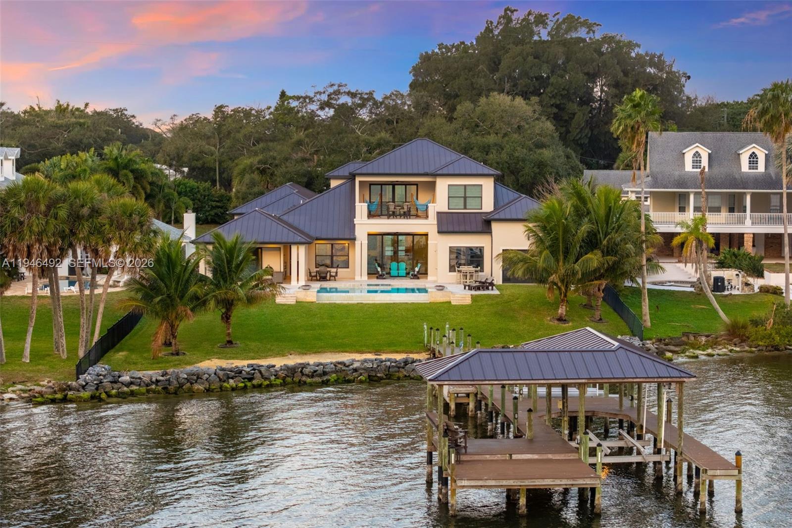 A two-story house with a metal roof, swimming pool, and private dock on the water — 6275 N Highway 1, Melbourne FL 32940, MELBOURNE, FL