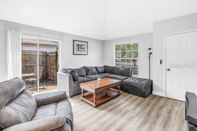 A living room features gray sectional seating, a wooden coffee table, and sliding glass doors — 2672 MEGAN COURT, PALM HARBOR, FL