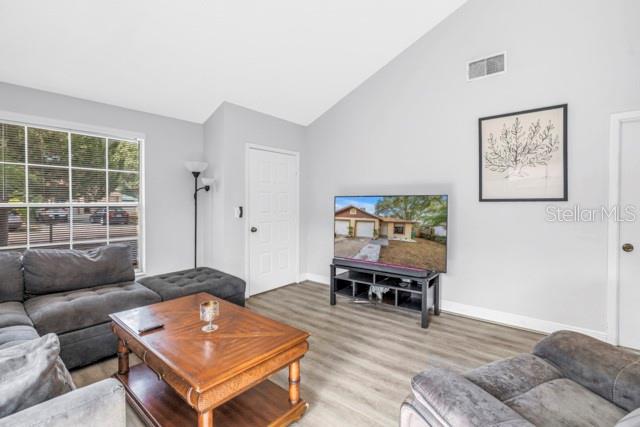 A living room features a grey sectional sofa, a wooden coffee table, and a television — 2672 MEGAN COURT, PALM HARBOR, FL