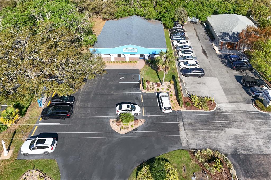 An aerial view shows a commercial property outlined in red along a multi-lane road — 205 E BURLEIGH BOULEVARD, TAVARES, FL