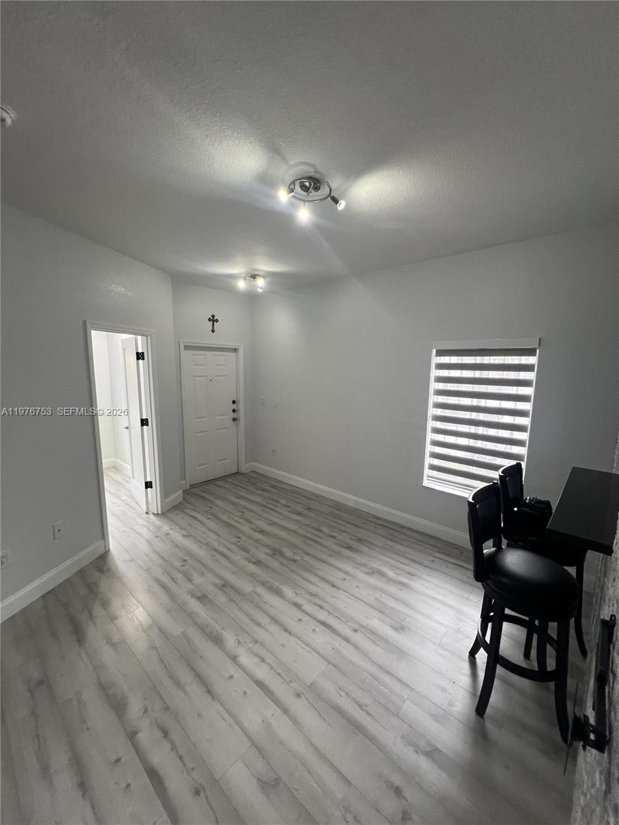 A room with light wood-look flooring, white walls, a doorway, and a window with blinds — 9000 W Flagler St # 1, Miami FL 33174, MIAMI, FL