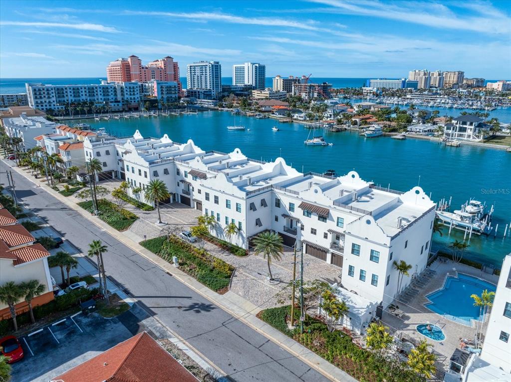 An aerial view of a white multi-story residential building located along a waterfront canal — 158 BRIGHTWATER DRIVE UNIT 2, CLEARWATER BEACH, FL