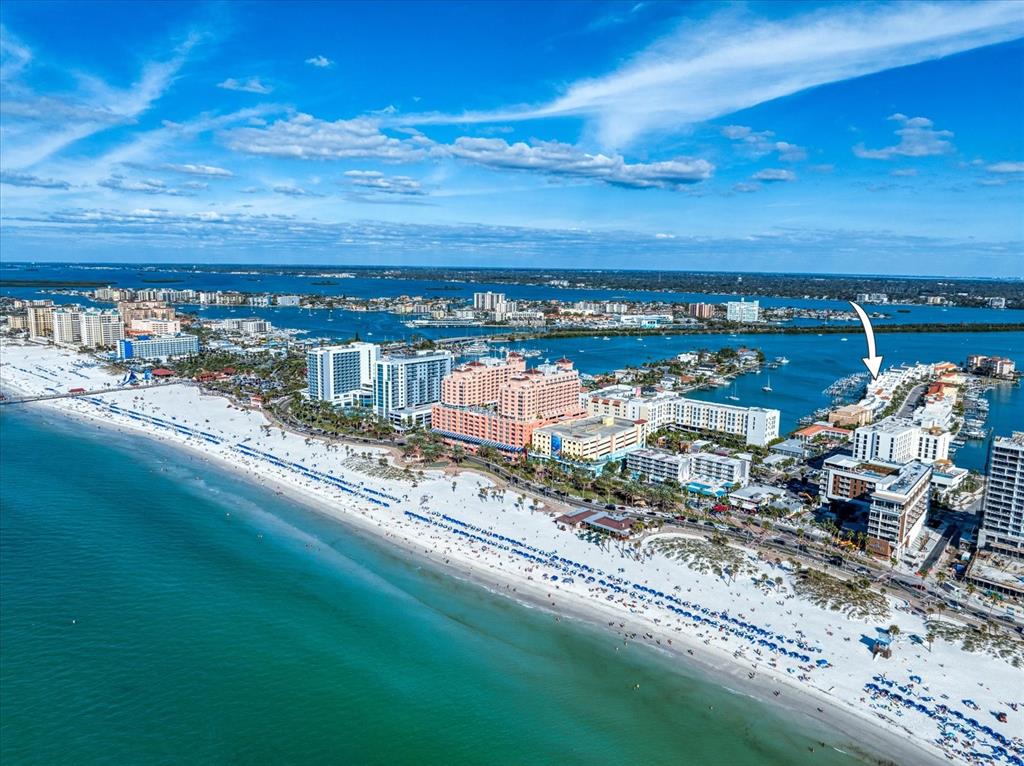An aerial view shows a sandy beach, resort hotels, and a marina on the coast — 158 BRIGHTWATER DRIVE UNIT 2, CLEARWATER BEACH, FL