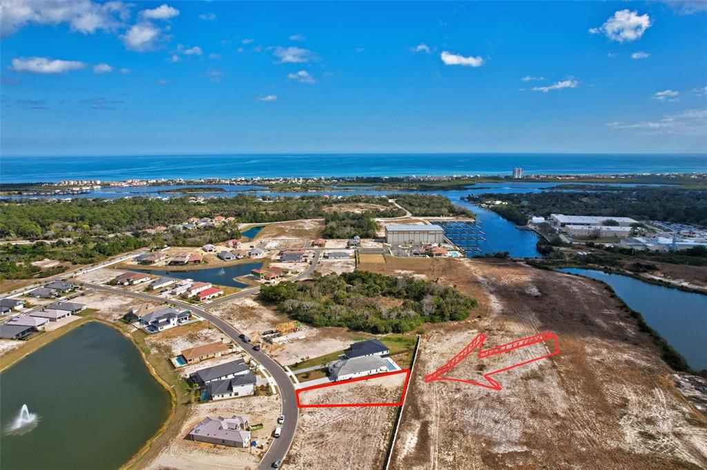 An aerial view shows a vacant residential lot outlined in red near a coastal waterway — 92 DEL PALMA DRIVE, PALM COAST, FL