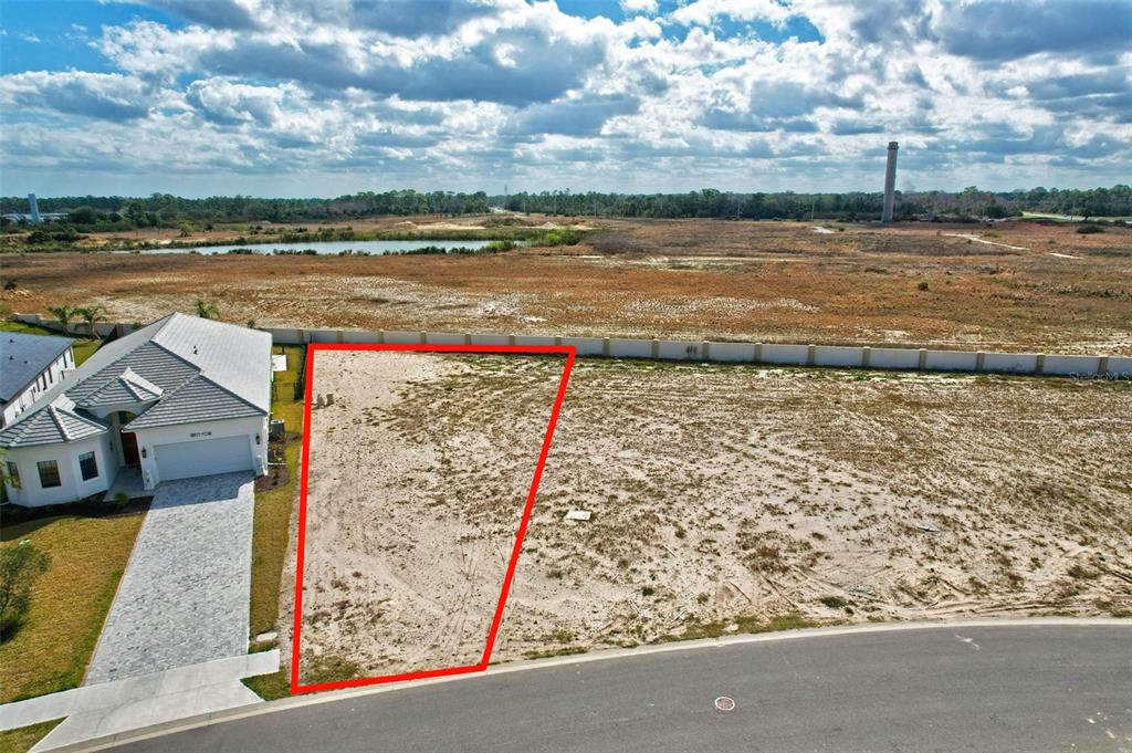 An aerial view shows a vacant, trapezoidal residential lot outlined in red next to a house — 92 DEL PALMA DRIVE, PALM COAST, FL