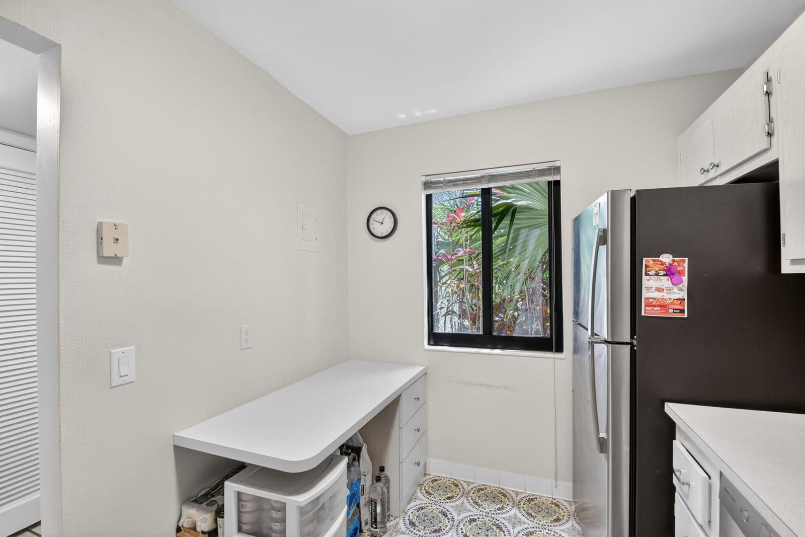 A kitchen area features a white desk, a stainless steel refrigerator, and patterned floor tiles — 4272 Deste Court # 101, Lake Worth FL 33467, LAKE WORTH, FL