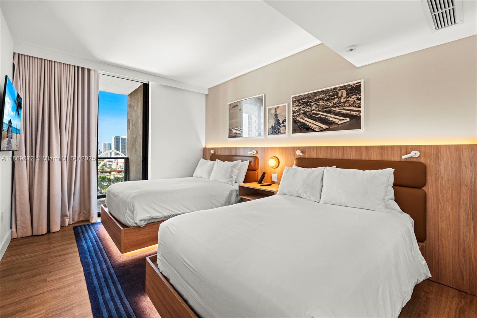 A hotel room features two beds, wood-paneled headboards, and a balcony with a city view — 601 NE 1st Ave # 1803, Miami FL 33132, MIAMI, FL