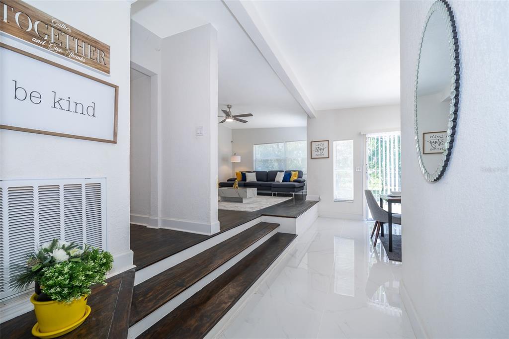 A split-level living area features dark wood flooring, white tile, and a sunken living room — 5815 WOLF ROAD, ORLANDO, FL