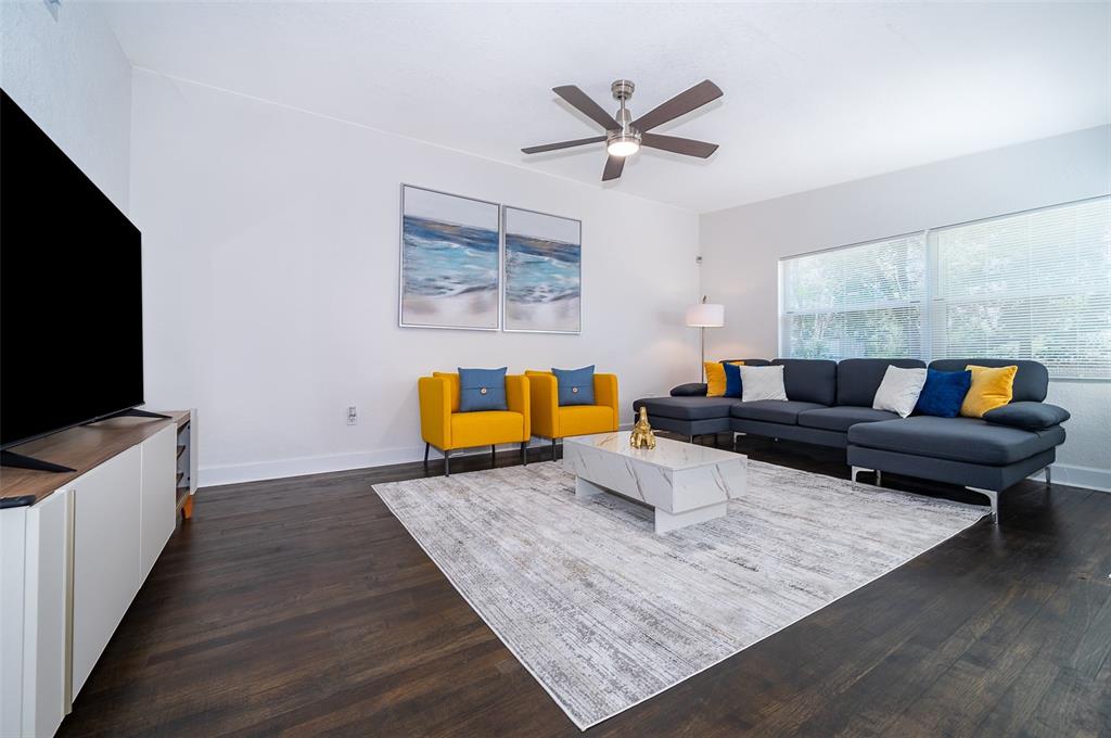 A living room features a dark sectional sofa, two yellow armchairs, and a marble coffee table — 5815 WOLF ROAD, ORLANDO, FL