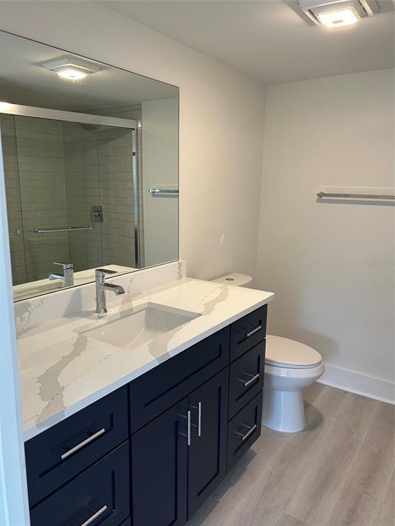 A bathroom features a dark vanity with a white countertop, a toilet, and a tub-shower — 4520 OVERLOOK DRIVE NE UNIT 132, ST PETERSBURG, FL
