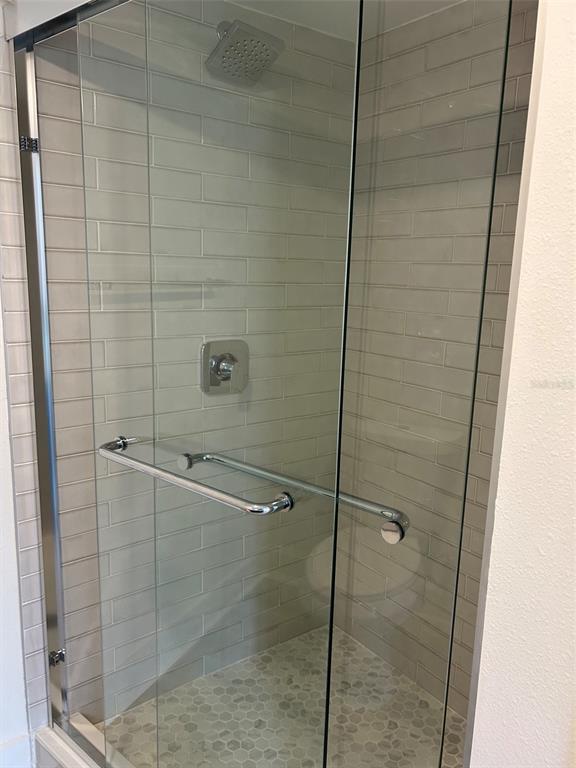A bathroom features a dark blue vanity with a white quartz countertop and a mirror — 4520 OVERLOOK DRIVE NE UNIT 132, ST PETERSBURG, FL