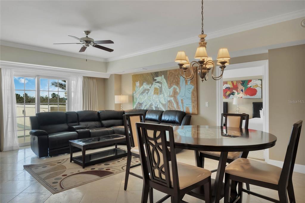 A living and dining area features a black leather sectional, round table, and large artwork — 7593 GATHERING DRIVE UNIT 206, REUNION, FL