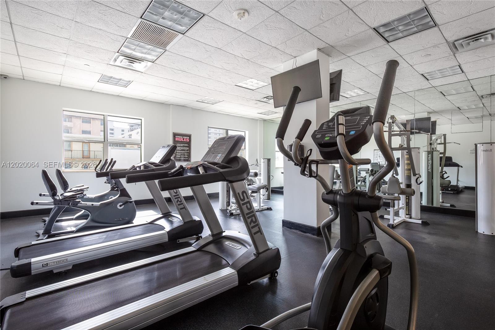A fitness center features treadmills, an elliptical machine, and a mirrored wall — 401 69th St # 1509, Miami Beach FL 33141, MIAMI BEACH, FL