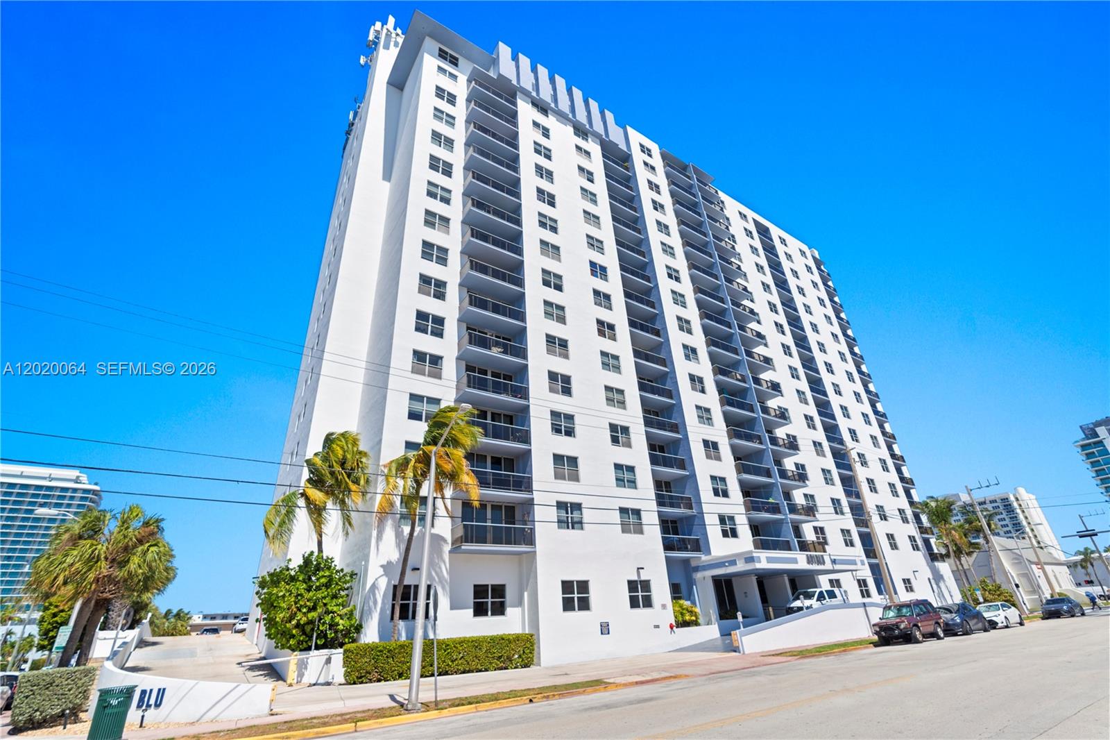 A tall white residential high-rise building stands under a clear blue sky — 401 69th St # 1509, Miami Beach FL 33141, MIAMI BEACH, FL