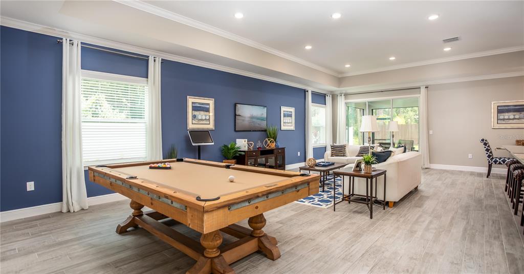 A spacious game room features a pool table, blue accent wall, and adjacent seating area — TBD lot 1 JAGUST ROAD, NORTH PORT, FL