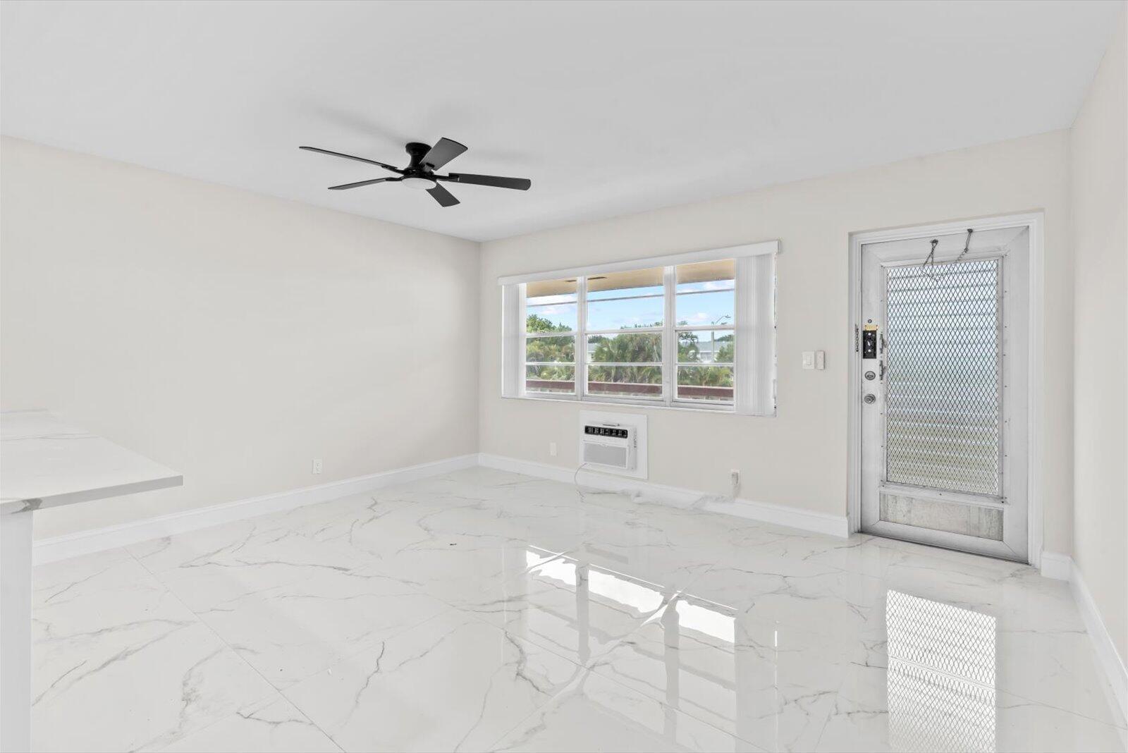 A bright room with white marble-style flooring, a ceiling fan, and a window air conditioner — 17 Andover A, West Palm Beach FL 33417, WEST PALM BEACH, FL