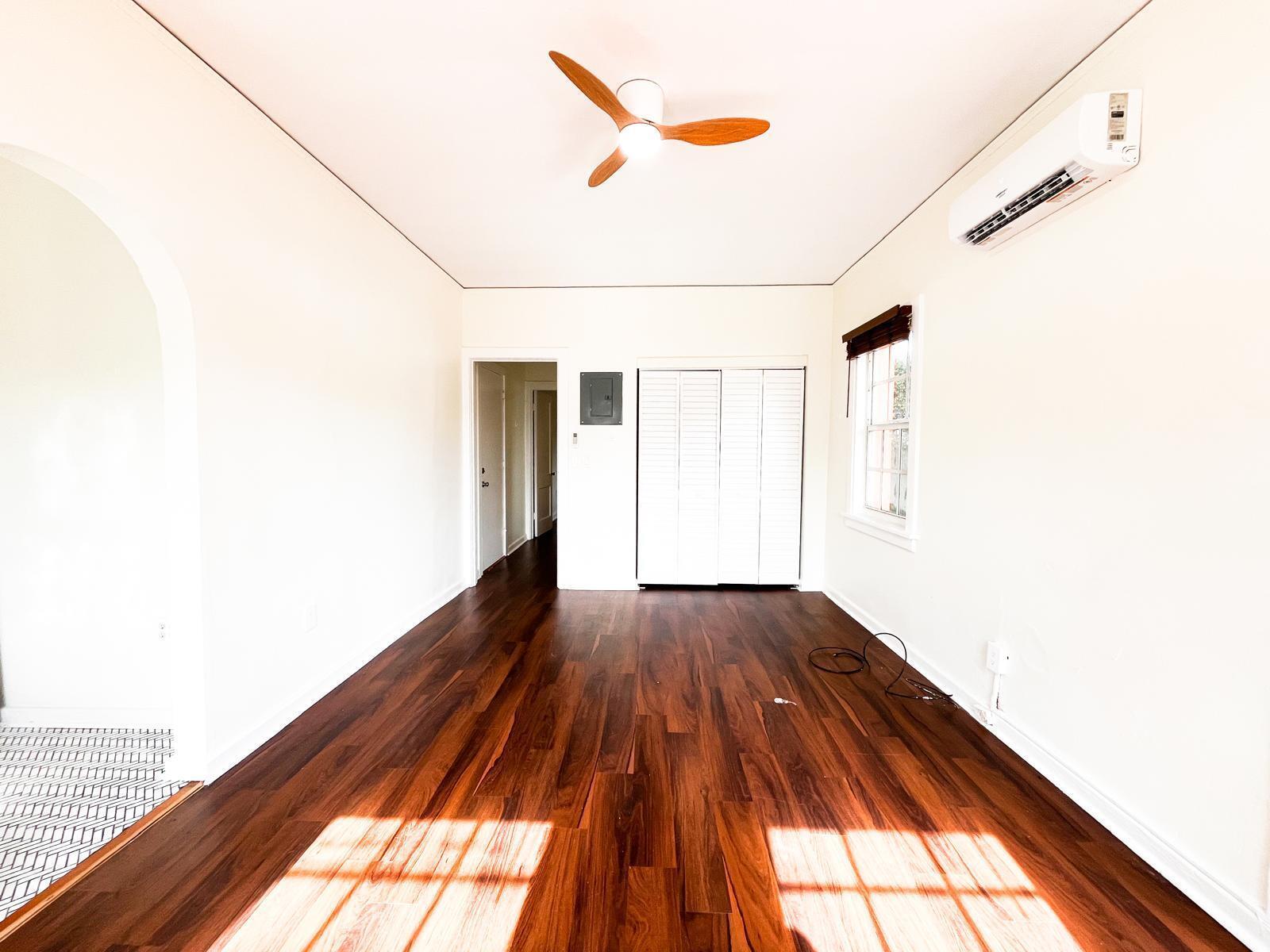 An empty room with dark wood flooring, a ceiling fan, and a wall-mounted air conditioner — 623 Park Place # 6, West Palm Beach FL 33401, WEST PALM BEACH, FL