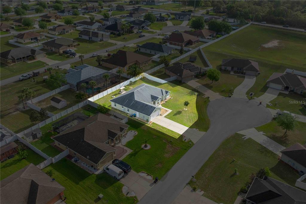 An aerial view shows a single-story house with a white fence and driveway — 9957 SW 55TH AVENUE ROAD, OCALA, FL
