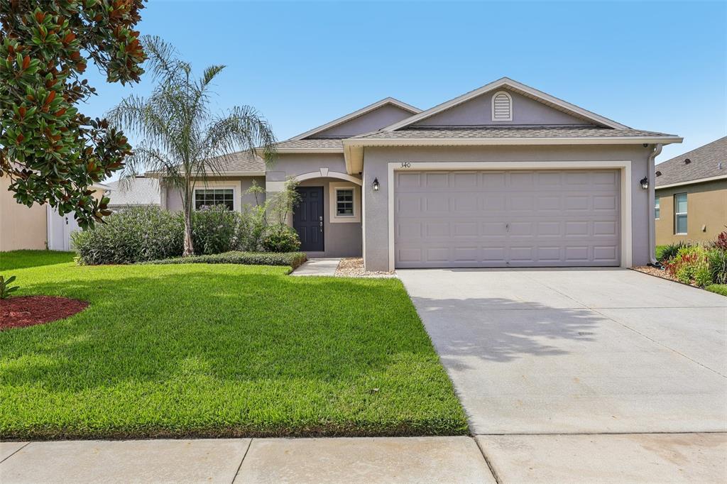 A single-story house with a gray stucco exterior, a two-car garage, and a front lawn — 340 BELLA ROSA CIRCLE, SANFORD, FL