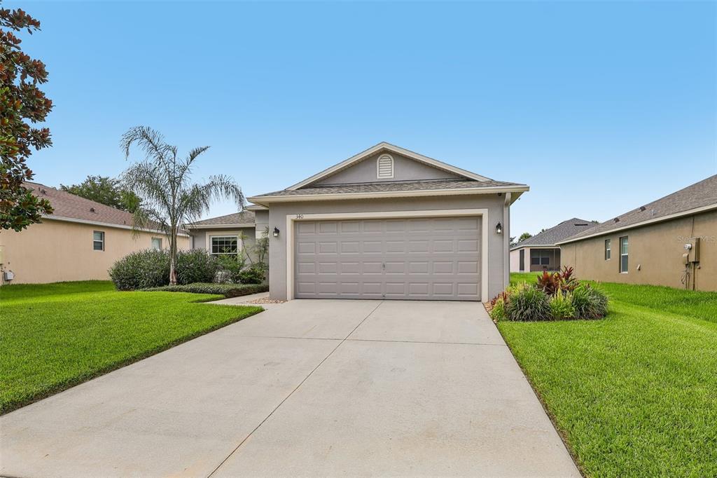 A single-story suburban house with a gray exterior, a two-car garage, and a concrete driveway — 340 BELLA ROSA CIRCLE, SANFORD, FL