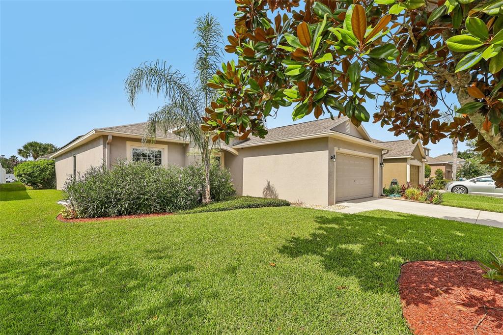 A single-story house with a beige stucco exterior, a two-car garage, and a front lawn — 340 BELLA ROSA CIRCLE, SANFORD, FL