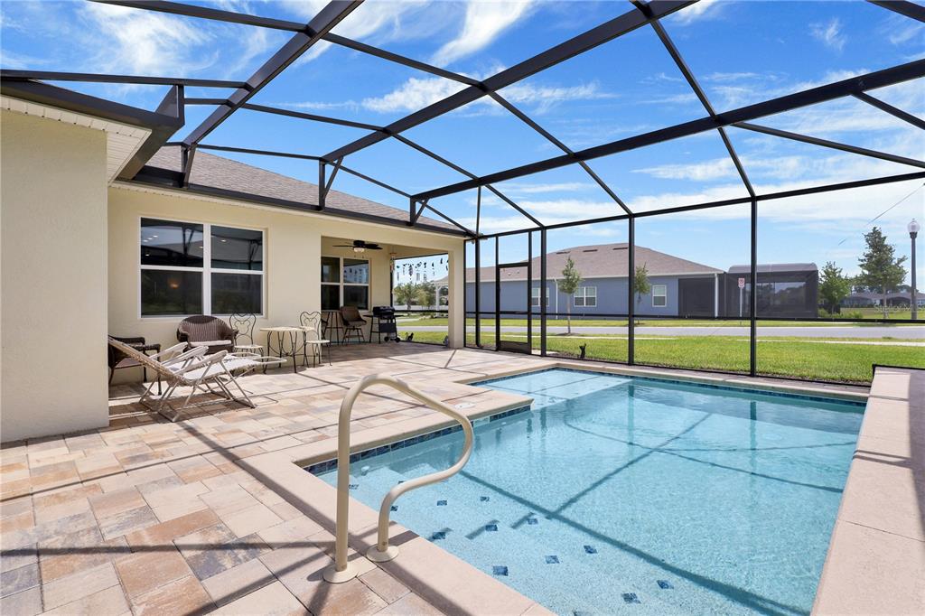 A screened-in patio features a swimming pool, paved deck, and outdoor seating area — 13175 SUNNY RETREAT LANE, WINTER GARDEN, FL